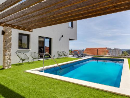 a swimming pool in the backyard of a house at Apartment Minimalist by Interhome in Šibenik