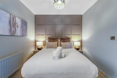 ダーリントンにあるInviting 3 Bedroom Flat in Corner House, Sleeps 6のベッドルーム1室(白いベッド1台、タオル2枚付)