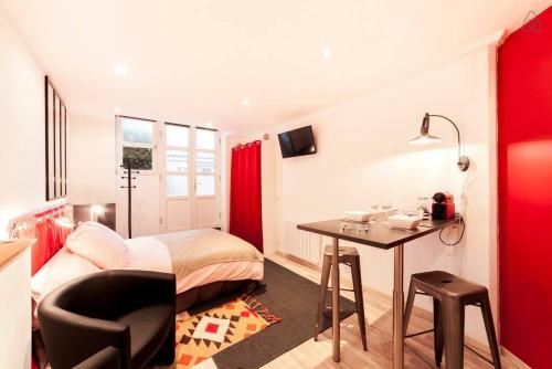 une chambre avec un lit et un bureau avec une chaise dans l'établissement Le studio de la place Saint-Jean du Vieux Lyon AIL, à Lyon
