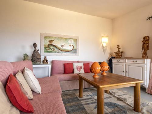 a living room with a pink couch and a table at Apartment 0-1-M - Marineledda by Interhome in Golfo Aranci
