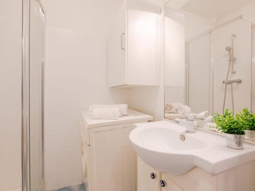 une salle de bain blanche avec un lavabo et un miroir dans l'établissement Apartment L'Espelido-7 by Interhome, à Saint-Aygulf