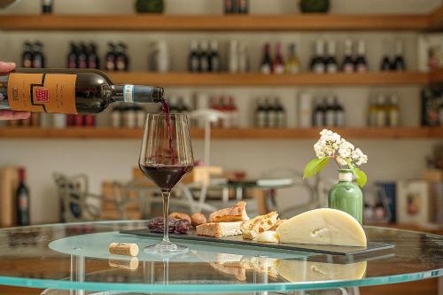 a person pouring wine into a glass on a table at Giardino Delle Oche - Ocone Taburno Wine County in Ponte