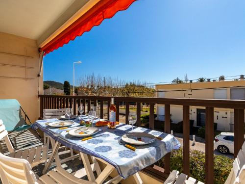 - une table sur un balcon avec une bouteille de vin dans l'établissement Apartment le Florida-2 by Interhome, à Saint-Cyr-sur-Mer