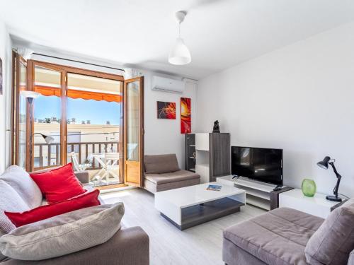 un salon avec un canapé et une télévision dans l'établissement Apartment le Florida-2 by Interhome, à Saint-Cyr-sur-Mer