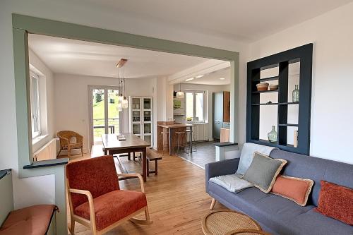 un salon avec un canapé bleu et une salle à manger dans l'établissement Le Chemin des Cerisiers - Maison vue montagne, à Le Tholy