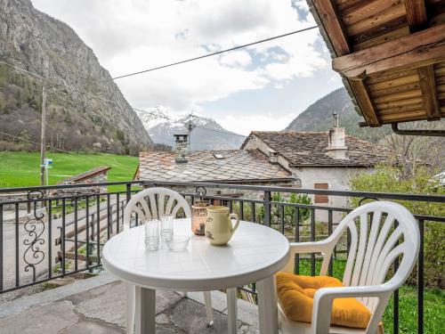einen weißen Tisch und Stühle auf einem Balkon mit Bergblick in der Unterkunft Holiday Home Maison Le Clapey by Interhome in Ollomont