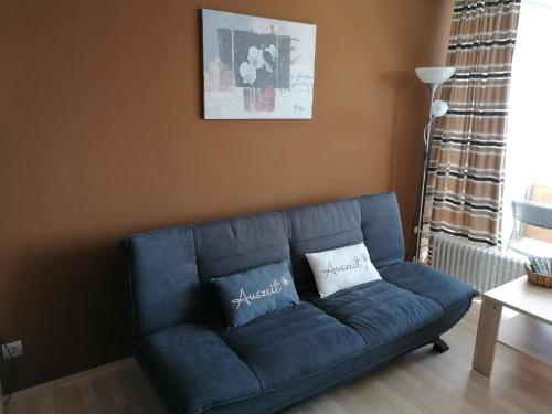 a blue couch with two pillows in a living room at Ferienwohnung Geyersberg in Freyung