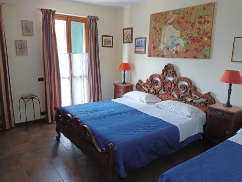 a bedroom with a large bed with a blue blanket at La Terrazza del Barbaresco in Neviglie