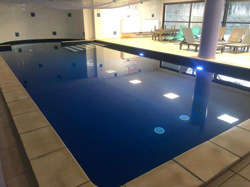 a large swimming pool in a building at Emplacement idéal, garage privé, piscine intérieure in Uzès