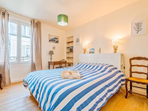 - une chambre avec un lit rayé bleu et blanc dans l'établissement Apartment Stella Maris by Interhome, à Dinard