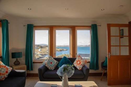 a living room with a couch and a large window at Castlebay View in Castlebay