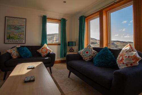 a living room with two couches and a table at Castlebay View in Castlebay