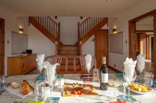 a table with a bottle of wine and some food at Castlebay View in Castlebay