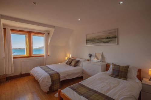 1 dormitorio con 2 camas y ventana en Castlebay View, en Castlebay