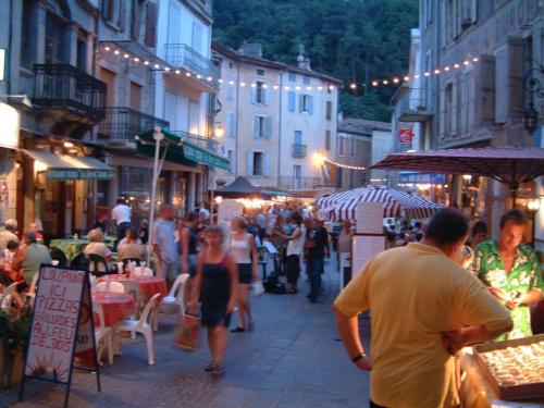 a crowd of people walking down a street at night at Gite au Rocher in Chassiers