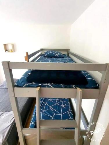 a bunk bed with blue pillows on top of it at Gite au Rocher in Chassiers