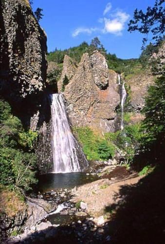 a waterfall in the middle of a rocky mountain at Gite au Rocher in Chassiers