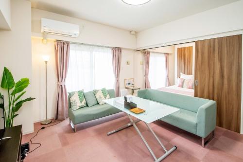 uma sala de estar com um sofá e uma cama em Hana House - Vacation STAY 14531v em Ginowan