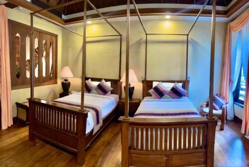 a bedroom with two beds in a room at Amata Lanna Village อมตะล้านนาวิลเลจ in Chiang Mai