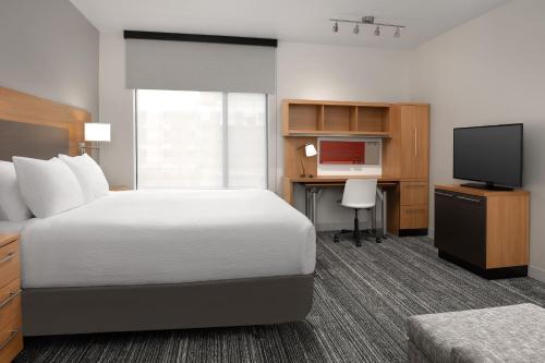a hotel room with a bed and a desk and a television at TownePlace Suites by Marriott Cheyenne Southwest/Downtown Area in Cheyenne