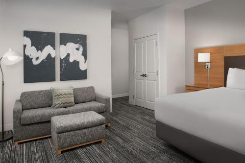 a bedroom with a bed and a couch and a chair at TownePlace Suites by Marriott Cheyenne Southwest/Downtown Area in Cheyenne
