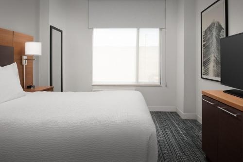 a hotel room with a bed and a television at TownePlace Suites by Marriott Cheyenne Southwest/Downtown Area in Cheyenne