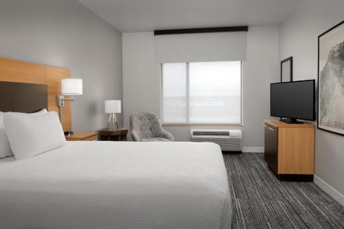 a hotel room with a bed and a television at TownePlace Suites by Marriott Cheyenne Southwest/Downtown Area in Cheyenne