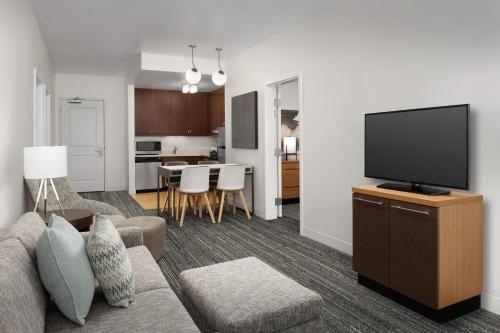 a living room with a couch and a flat screen tv at TownePlace Suites by Marriott Cheyenne Southwest/Downtown Area in Cheyenne