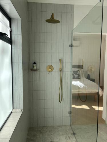 a shower with a glass door in a bedroom at Chasselas Self Catering in Cape Town