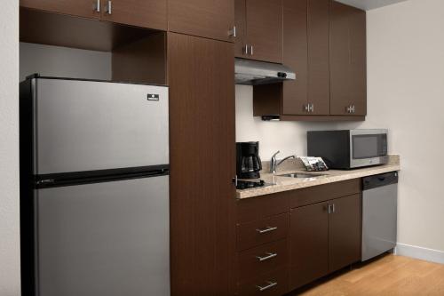 a kitchen with a refrigerator and a microwave at TownePlace Suites by Marriott Cheyenne Southwest/Downtown Area in Cheyenne