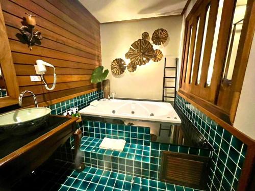a bathroom with a sink and a bath tub at Amata Lanna Village อมตะล้านนาวิลเลจ in Chiang Mai