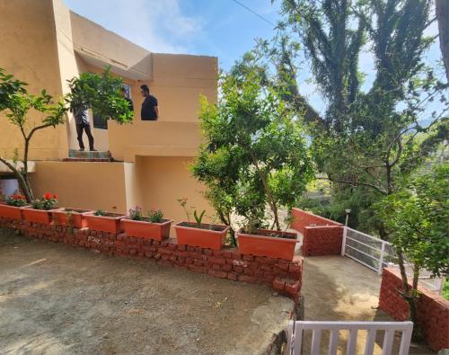 un homme assis sur le balcon d'une maison dans l'établissement Villa Kartina by the Hillstay, à Bhowāli