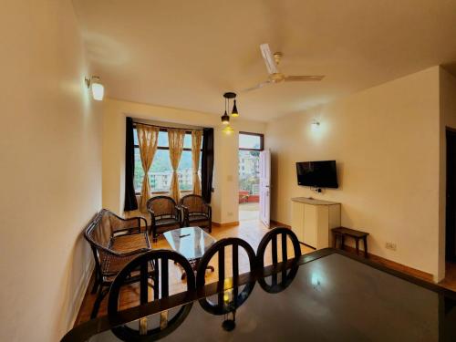 une salle à manger avec une table et des chaises en verre dans l'établissement Villa Kartina by the Hillstay, à Bhowāli