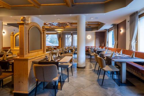a restaurant with tables and chairs and a mirror at Hotel Dolomiti Saone in Tione di Trento