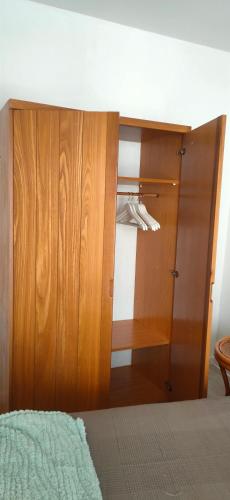 a bedroom with a closet with a wooden door at "Les Chacobins" - appart'étape avec Garage Vélos in La Réole