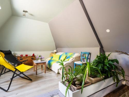 a room with a bed and a yellow chair and plants at Holiday Home Roucan by Interhome in Teyssieu