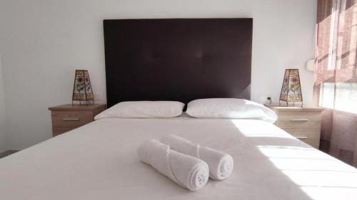 1 dormitorio con 1 cama blanca y 2 toallas en Fantástico apartamento totalmente renovado, en Torre del Mar