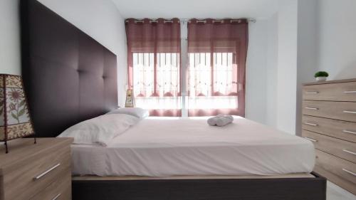 Un dormitorio con una cama grande y una ventana en Fantástico apartamento totalmente renovado, en Torre del Mar