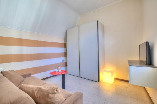 a living room with a couch and a tv at Appartamento Gabriella - Happy Rentals in Laveno-Mombello