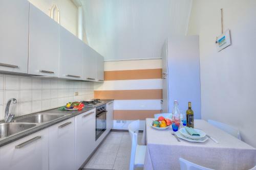a kitchen with a sink and a table with a bowl of fruit at Appartamento Gabriella - Happy Rentals in Laveno-Mombello