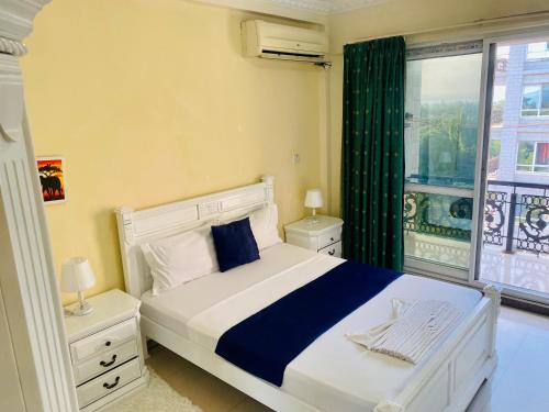 a bedroom with a large bed and a window at Platinum apartment in Dar es Salaam