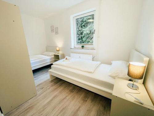 a white room with a bed and a window at Monty - Kitchen - Washer - Free Parking - SMART-TV in Goslar