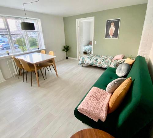 a living room with a green couch and a table at 5 minute walk to LEGO house - 50m2 cozy apartment- D unit in Billund