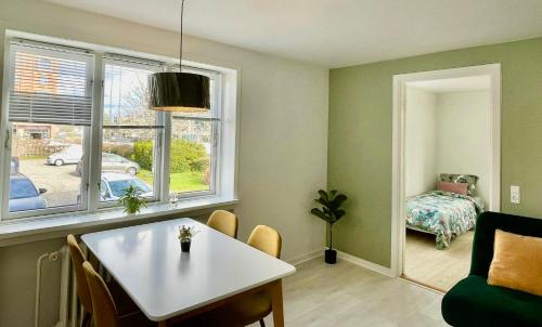 a living room with a table and a window at 5 minute walk to LEGO house - 50m2 cozy apartment- D unit in Billund