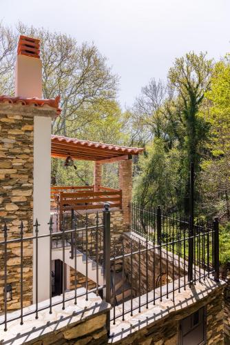a building with a deck with a fence at Stone Nest in Samos