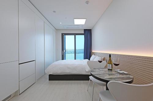 a bedroom with a bed and a table with wine glasses at World Sky Residence Hotel in Sokcho