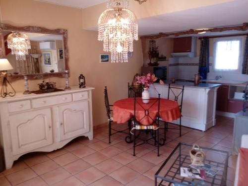 une cuisine avec une table et un lustre dans l'établissement Villa 16, La Palmeraie, au village naturiste, au Cap d'Agde