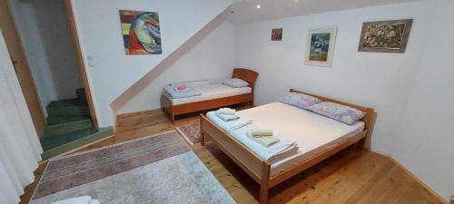 Habitación pequeña con 2 camas y escalera. en Apartman u Kuci u Konjicu en Konjic