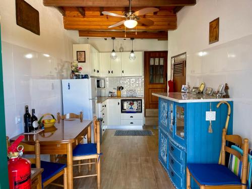 a kitchen with a table and a blue refrigerator at Casa David in Castelo de Vide
