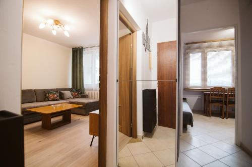 een woonkamer met een bank en een tafel bij Nowy dwupokojowy Apartament 700 m od Szpitala Prokocim in Krakau
